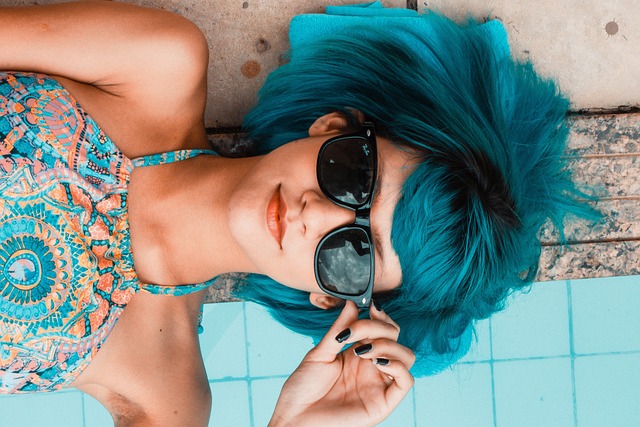 Woman lying by pool with blue hair and sunglasses - by Daniel Sampaio from Pixabay