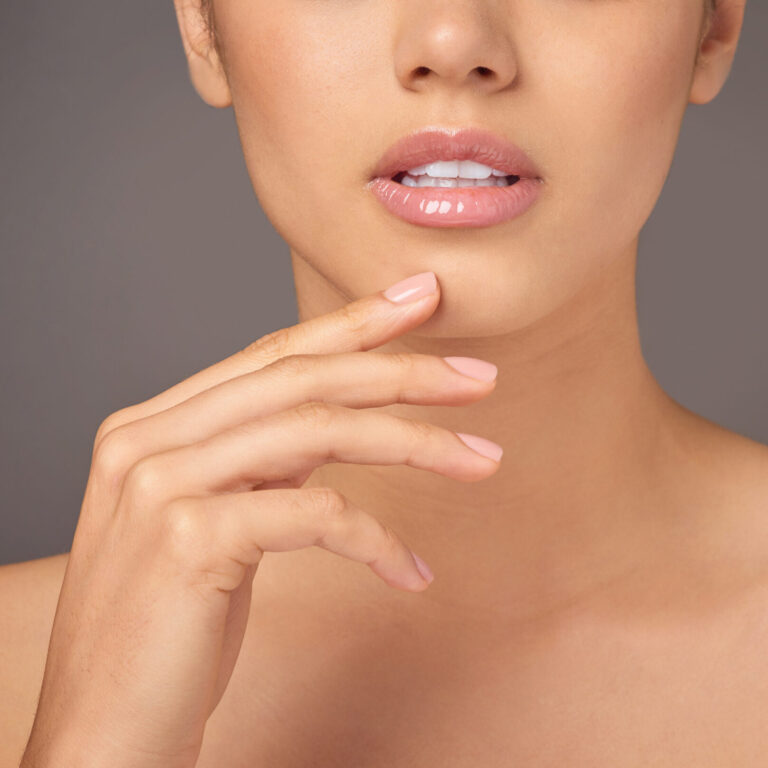 Makeup, beauty and lips of girl in studio with kiss, closeup and glossy mouth with healthy glow. Skincare, cosmetics and woman with natural lipstick color, luxury filler and shine on gray background.